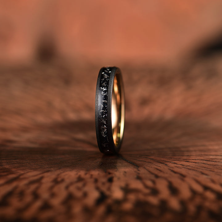 Womans rose tungsten wedding ring with crushed meteorite inlay with a sandblasted black finish.